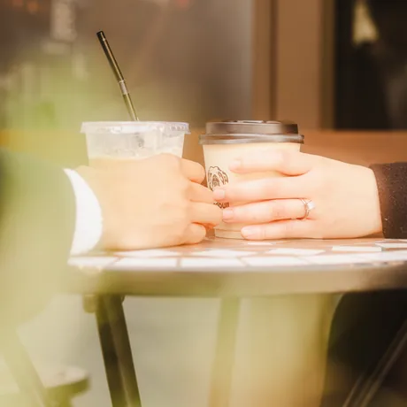 Eden's hand on a coffee cup, her new ring catching the light